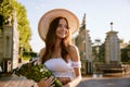 Gentle beautiful young woman holding wildflower bouquet in park