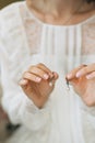 A gentle bride in a lace wedding dress holds earrings with pearls Royalty Free Stock Photo