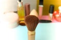 Gentle brush of natural lint for applying powder on the background of a cosmetic table for makeup for beauty guidance