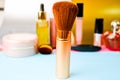 Gentle brush of natural lint for applying powder on the background of a cosmetic table for makeup for beauty guidance