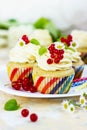 Gentle cupcake with cream and berries on a light background