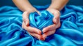 Gentle female hands shape a heart from luxurious blue silk, symbolizing love and care Royalty Free Stock Photo