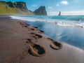 Gentle footprints in the sand leading towards the ocean