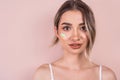 gentle girl with light makeup on a pink background with foundation on her face