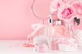 Gentle girlish dressing table with round mirror, flowers and cosmetics products - rose oil, bath salt, cream, perfume. Royalty Free Stock Photo