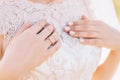 The gentle hands of the bride c a wedding ring on a lace dress