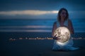 Gentle image of a girl, Astrology, Female magic. Beautiful attractive girl on a night beach with sand hugs the moon, art Royalty Free Stock Photo