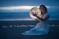 Gentle image of a girl, Astrology, Female magic. Beautiful attractive girl on a night beach with sand hugs the moon, art