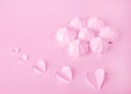 A gentle meringue kiss. Pink monochrome. On the background with hearts on Valentine`s Day. Selective focus