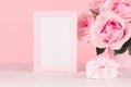 Gentle mockup for Valentines day - blank frame for text, soft light pink roses bouquet and gift box with ribbon on white wood. Royalty Free Stock Photo