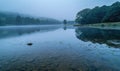 A gentle morning mist over a tranquil lake with soft reflections Royalty Free Stock Photo