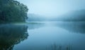 A gentle morning mist over a tranquil lake with soft reflections Royalty Free Stock Photo
