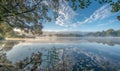 A gentle morning mist over a tranquil lake with soft reflections Royalty Free Stock Photo