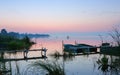 Gentle Pink-Blue Dawn Before Sunrise Over the Overgrown Shore of a Calm Lake with Moored Boats Royalty Free Stock Photo