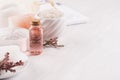 Gentle pink cosmetics oil, small flowers and white soap, cream, clay, towel closeup on white wooden background, copy space. Royalty Free Stock Photo