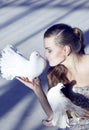 Gentle portrait of a beautiful girl with a white dove, over a s