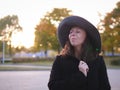 gentle portrait of a beautiful woman in a large hat and black coat Royalty Free Stock Photo