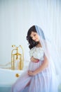 Gentle pregnancy. Beautiful pregnant in light white dress with orchids Royalty Free Stock Photo