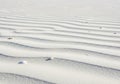 Gentle ripples of white sand stretch across the image, creating an undulating pattern. The sand is Royalty Free Stock Photo