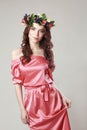 Gentle romantic appearance of the girl with a wreath of roses on her head and a pink dress. Joyful Jolly spring woman. Summer lady Royalty Free Stock Photo