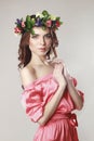 Gentle romantic appearance of the girl with a wreath of roses on her head and a pink dress. Joyful Jolly spring woman. Summer lady Royalty Free Stock Photo