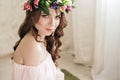 Gentle romantic appearance of the girl with a wreath of roses on her head and a pink dress. Joyful Jolly spring woman. Summer lady Royalty Free Stock Photo