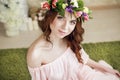 Gentle romantic appearance of the girl with a wreath of roses on her head and a pink dress. Joyful Jolly spring woman. Summer lady Royalty Free Stock Photo