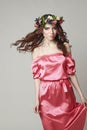 Gentle romantic appearance of the girl with a wreath of roses on her head and a pink dress. Joyful Jolly spring woman. Summer lady Royalty Free Stock Photo