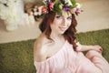 Gentle romantic appearance of the girl with a wreath of roses on her head and a pink dress. Joyful Jolly spring woman. Summer lady Royalty Free Stock Photo