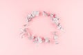 Gentle simple decorative blank wreath of silver branches with copy space on pastel pink background, top view.