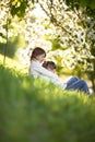 Gentle sisters hug apple blossom, sunny childhood