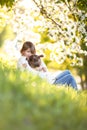 Gentle sisters hug apple blossom, sunny childhood