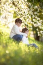 Gentle sisters hug apple blossom, sunny childhood