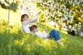 Gentle sisters hug apple blossom, sunny childhood