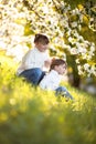 Gentle sisters hug apple blossom, sunny childhood