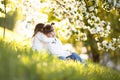 Gentle sisters hug apple blossom, sunny childhood