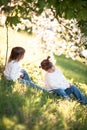 Gentle sisters hug apple blossom, sunny childhood