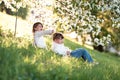 Gentle sisters hug apple blossom, sunny childhood