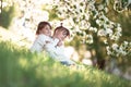 Gentle sisters hug apple blossom, sunny childhood