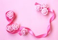Gentle spring background with pink silk ribbon, rose flowers