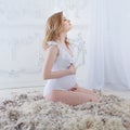 Gentle and sweet pregnant woman in the image of a mother bird in the nest, concept. Young blonde woman waiting for baby.
