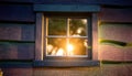 A gentle warm light glowing from a cottage window on a calm, quiet night Royalty Free Stock Photo