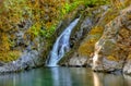 Gentle waterfall pours into a clear pool of water in Rogue River Oregon