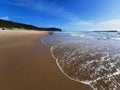 Gentle wave coming to the fine brown sandy beach in the afternoon