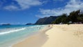 Gentle wave lap on Waimanalo Beach as people play in the water