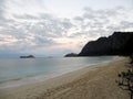 Gentle wave lap on Waimanalo Beach looking towards Rabbit island and Rock island at dusk Royalty Free Stock Photo