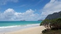 Gentle wave lap on Waimanalo Beach looking towards Rabbit island and Rock island on a nice day with clouds in the sky Royalty Free Stock Photo