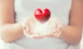Gentle Womens Hands And A Red Heart Glowing In His Hands. Valentines Mothers Day And Charity Concept