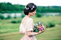 Gentle young woman with a beautiful bouquet enjoys a spring day. Creative hairstyle with butterflies Royalty Free Stock Photo