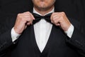 Gentleman in Black Tie Straightens His Bowtie